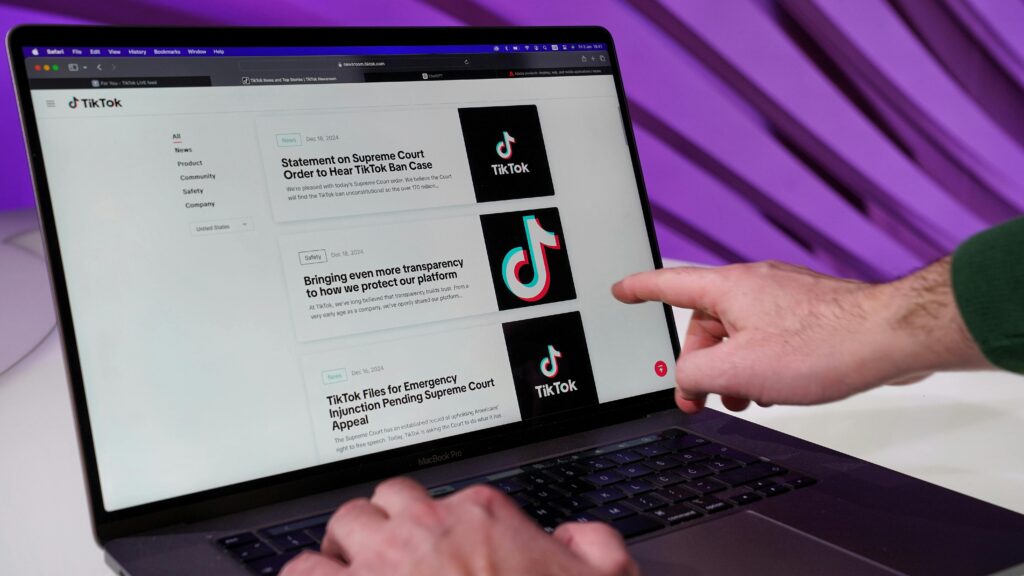 Close-up of a person interacting with TikTok content on a laptop indoors.